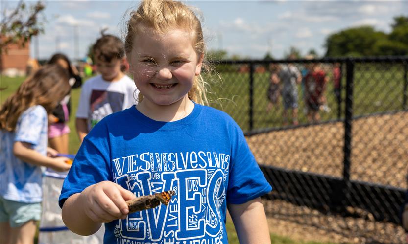 Students smile while releasing butterflies outside
